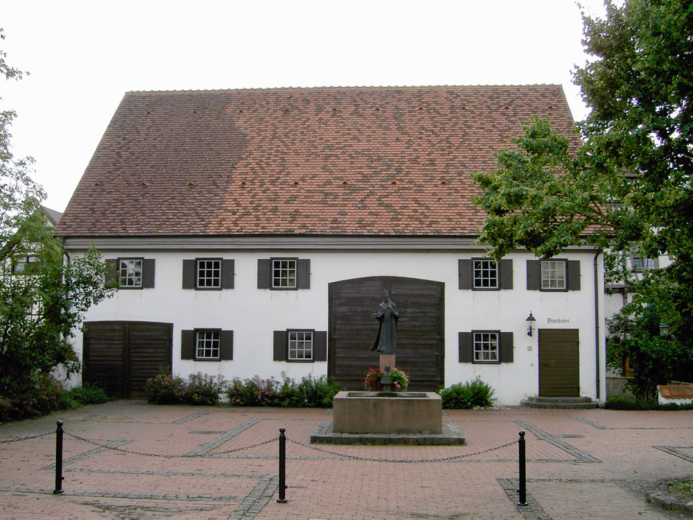 Frontalansicht Pfarrstadel mit Brunnen im Vordergrund